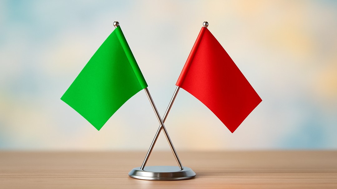 An image of a red flag and a green flag illustrate an op-ed on how to spot authentic impact jobs.